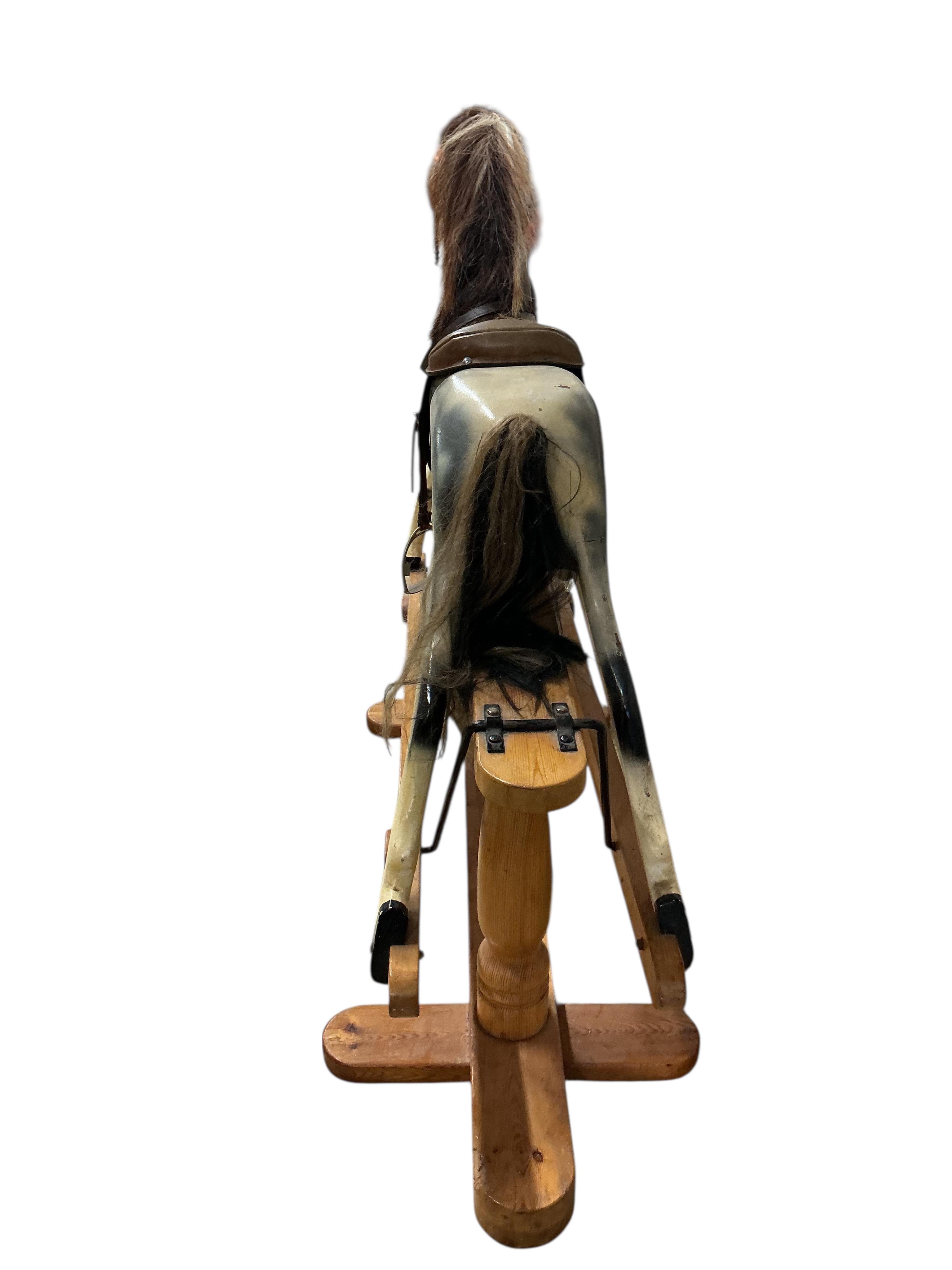 A modern dapple grey rocking horse, unsigned, on a pine base, height to the top of the head 109cm, overall length 136cm